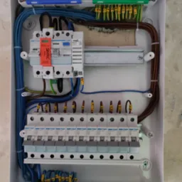 Rozdzielnica elektryczna Hager z zainstalowanymi bezpiecznikami i przewodami oznaczonymi numerami, widok z góry w trakcie montażu.