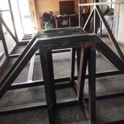 PAZ-MET PRZEMYSŁAW PAZIO - Konstrukcja metalowa z profili, prawdopodobnie szkielet pod budowę, widoczne spawy i oznaczenia na metalu, warsztatowe tło.