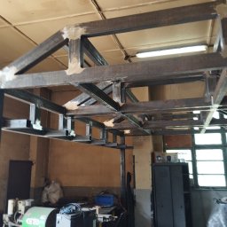 PAZ-MET PRZEMYSŁAW PAZIO - Szkielet stalowej konstrukcji spawanej, widoczne spoiny, w tle sprzęt warsztatowy, w tym kompresor ATMOS.