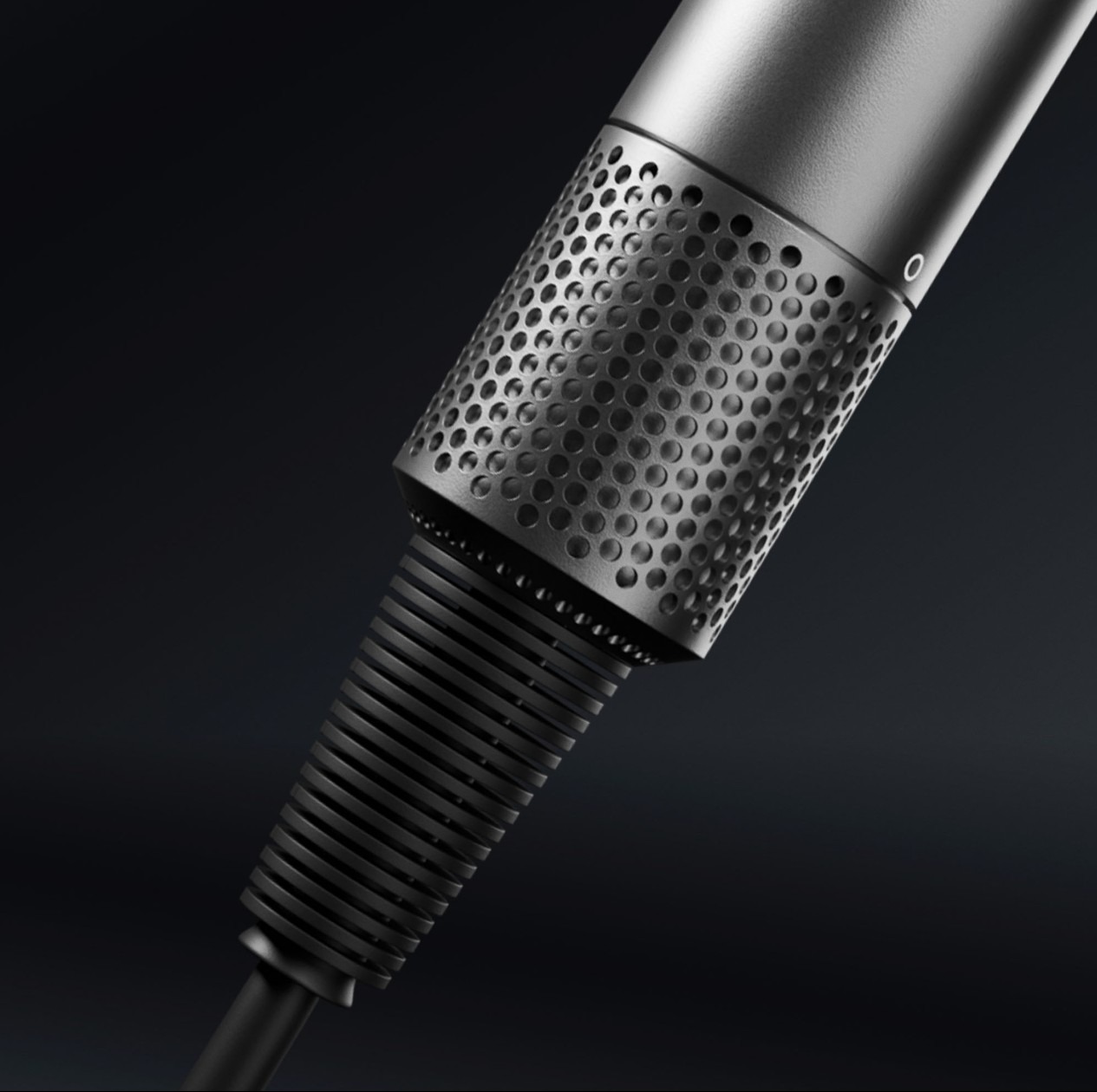 Szczegółowe ujęcie metalowej obudowy urządzenia elektronicznego z perforowaną powierzchnią, być może elementu sprzętu komputerowego, sfotografowane w Warszawie na ciemnym tle.