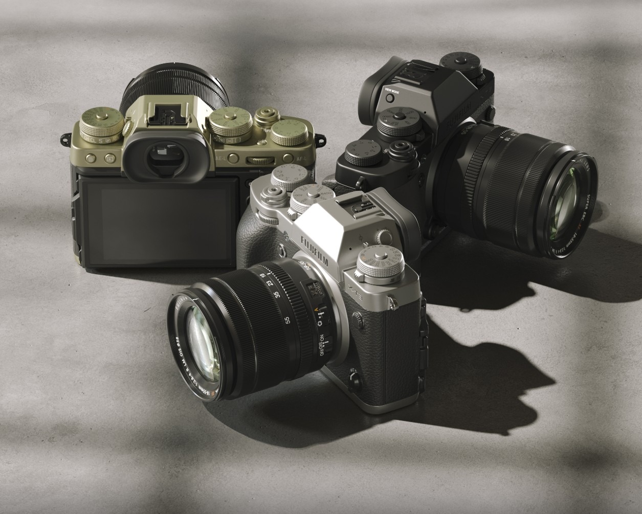 Trzy aparaty Fujifilm X-T4 w kolorach srebrnym, czarnym i zielonym, ustawione na szarym tle w studyjnym oświetleniu, z widocznymi obiektywami i elementami sterującymi.