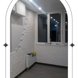 Svitlana REM - Wykończony balkon z białymi cegiełkami na ścianach, szarymi panelami podłogowymi i białym grzejnikiem pod oknem.