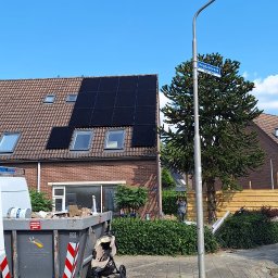 DN-ELEKTRO Daniel Niziński - Dom z panelami słonecznymi na dachu, widoczny kontener na śmieci, w tle osoba przy ogrodzeniu i tablica z nazwą ulicy Hegdambroek.