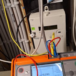 DN-ELEKTRO Daniel Niziński - Elektryk wykonuje pomiary impedancji pętli zwarcia ZL-PE=5,21Ω za pomocą miernika Sonel MPI-520, widoczny licznik energii elektrycznej Landis+Gyr E360 oraz instalacja elektryczna w peszlach.