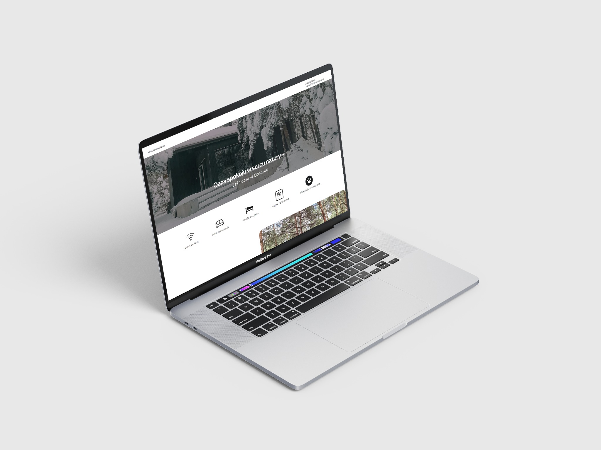 Ekran laptopa MacBook Pro wyświetla stronę internetową Leśniczówka Gorzewo z zimowym krajobrazem i ofertą noclegową.