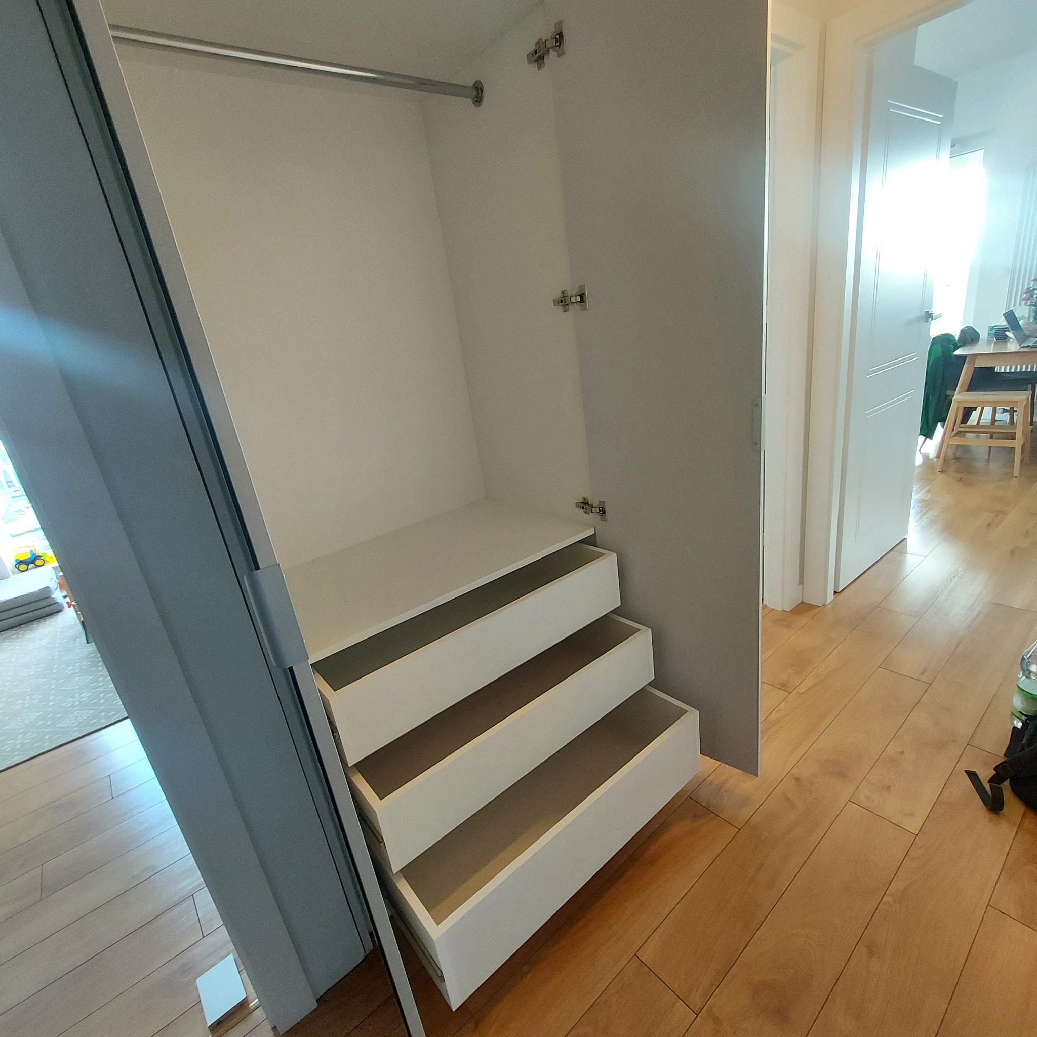 Wnętrze szafy wnękowej z trzema wysuwanymi szufladami, widok z boku, realizacja w Poznaniu.