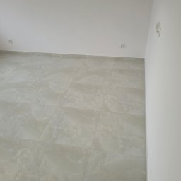 REMONTY PK TOMASZEWSCY SPÓŁKA Z OGRANICZONĄ ODPOWIEDZIALNOŚCIĄ - Wykończone wnętrze: jasne, marmurowe płytki podłogowe, białe ściany z gniazdkami i włącznikami. Minimalistyczny design, świeżo po remoncie.