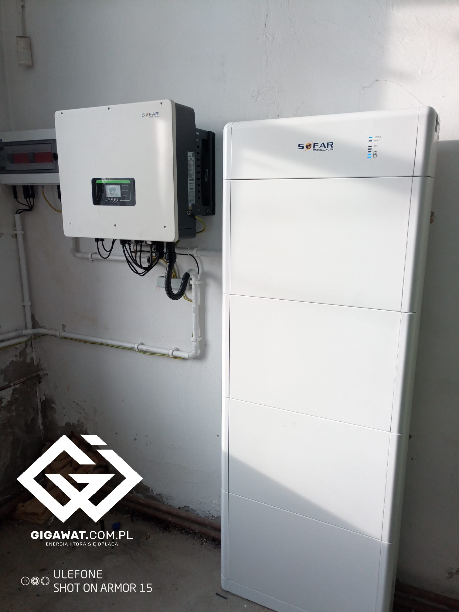 Zamontowany falownik hybrydowy Sofar i modułowy magazyn energii Sofar BTS w jasnym pomieszczeniu, widoczne okablowanie i elementy instalacji elektrycznej.