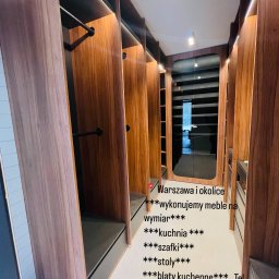 Vlad Tracenko - Wnętrze nowoczesnej garderoby na wymiar z drewnianymi panelami, czarnymi drążkami i szufladami, oświetleniem punktowym.