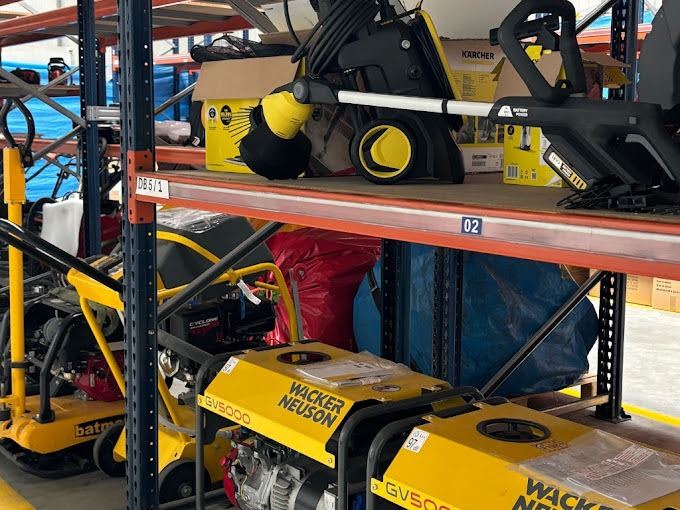 Magazyn we Wrocławiu z żółtymi zagęszczarkami Wacker Neuson GV5000 i myjkami ciśnieniowymi Kärcher na metalowych regałach.