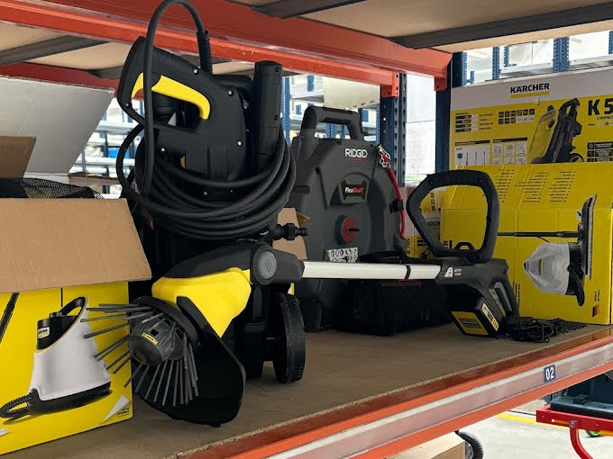 Sprzęt do czyszczenia: myjka ciśnieniowa Karcher, szczotka do czyszczenia powierzchni i urządzenie do udrażniania rur Ridgid FlexShaft na półce magazynowej.