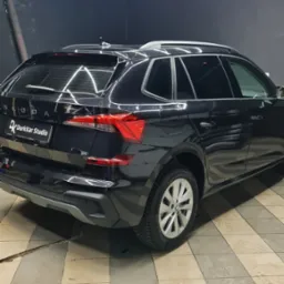 Czarne auto Skoda Kamik w studiu detailingu DarkKar, widok z tyłu, oświetlenie LED na suficie, płytki podłogowe.