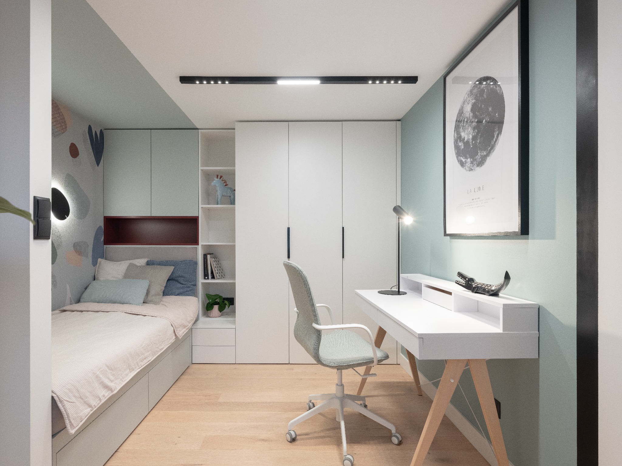 Pokój młodzieżowy z łóżkiem, biurkiem na drewnianych nogach, szafą i oświetleniem LED, ściany pomalowane na dwa kolory: biały i miętowy, dekoracyjne naklejki na ścianie za łóżkiem