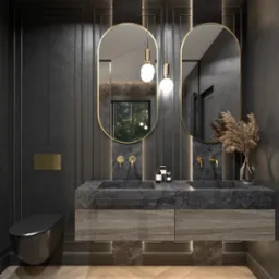 Elegancka łazienka z dwoma owalnymi lustrami w złotych ramach, kamiennym blatem z dwiema umywalkami, złotą armaturą i wiszącą toaletą w kolorze czarnym mat.