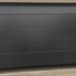 WFB MASZTALERZ SP Z O.O. - Zamknięta, segmentowa brama garażowa w kolorze antracytowym z poziomymi przetłoczeniami, widoczny fragment posadzki i ościeżnicy.