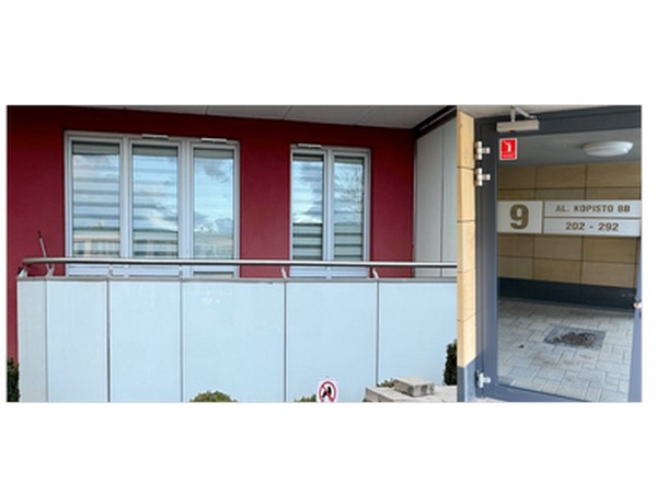 Budynek mieszkalny z balkonem i wejściem, widoczny adres 'Al. Kopisto 8B 202-292' nad drzwiami wejściowymi.