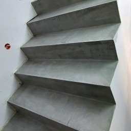 Mikrocement floor Design - Betonowe schody o minimalistycznym wyglądzie z widocznymi puszkami elektrycznymi w ścianie, świeżo po wykonaniu.