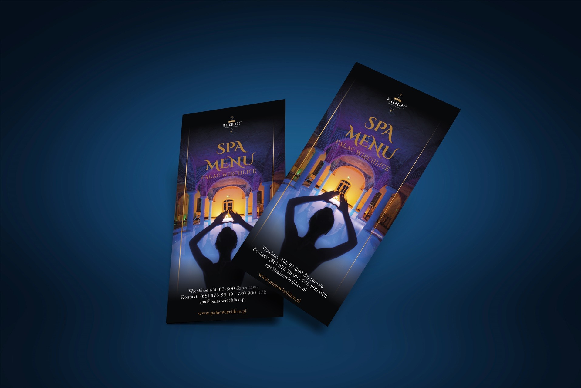 Dwa identyczne foldery reklamowe SPA Menu Pałac Wiechlice na ciemnoniebieskim tle, prezentujące sylwetkę kobiety na tle pałacowego dziedzińca.