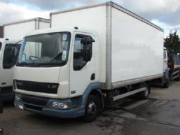 Biała ciężarówka dostawcza DAF LF z zabudową kontenerową, zaparkowana na placu z szarym podłożem, widok z boku, lekko od przodu.