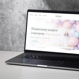 Sketch studio - Laptop wyświetlający stronę internetową z dekoracjami balonowymi na tle szarej, teksturowanej ściany. Strona zawiera logo 'Hooray!' i hasło 'Dostarczamy szczęście i tworzymy Wspomnienia'.