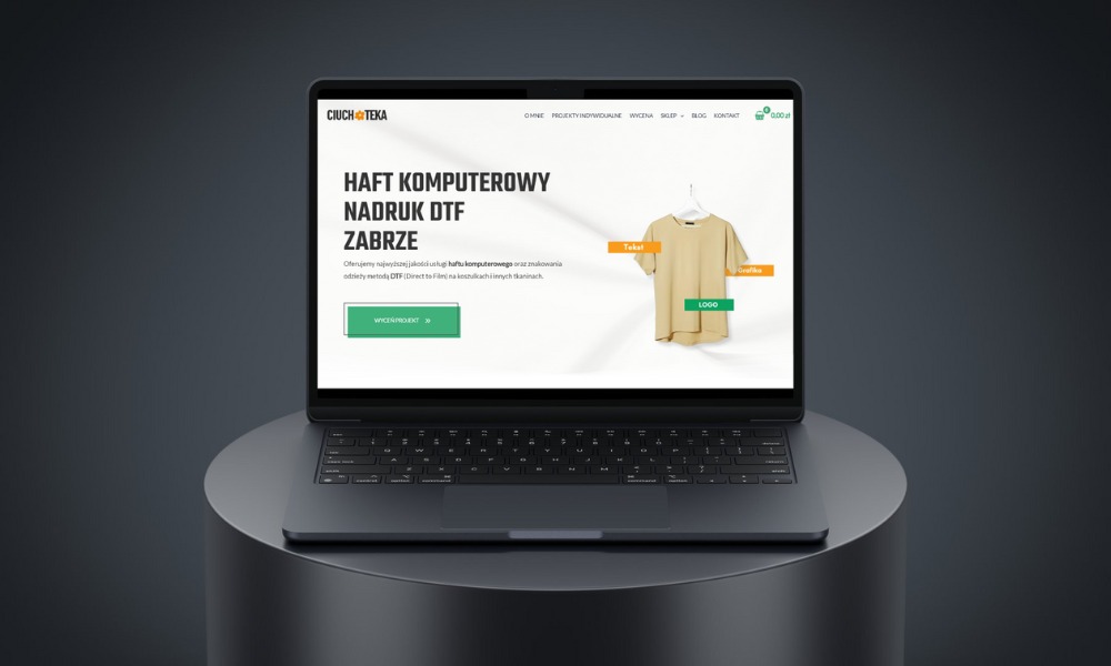 Laptop wyświetlający stronę internetową firmy oferującej haft komputerowy i nadruk DTF na odzieży, z przykładową koszulką na wirtualnym wieszaku.