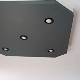 Szary, wielokątny podwieszany sufit z pięcioma okrągłymi lampami punktowymi, widok z dołu.