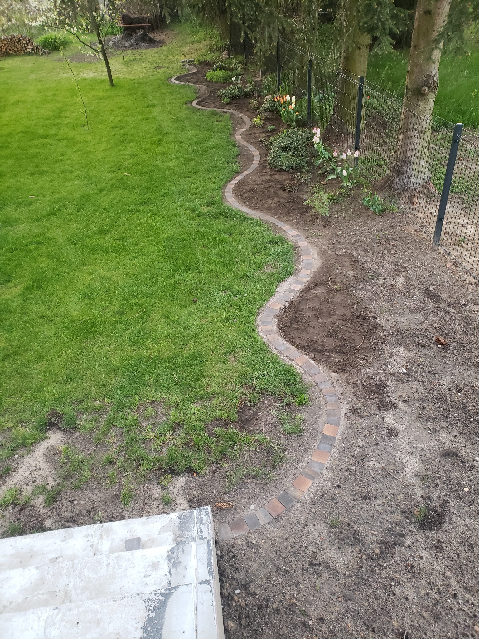 Wykonane obrzeże trawnikowe z kostki brukowej.