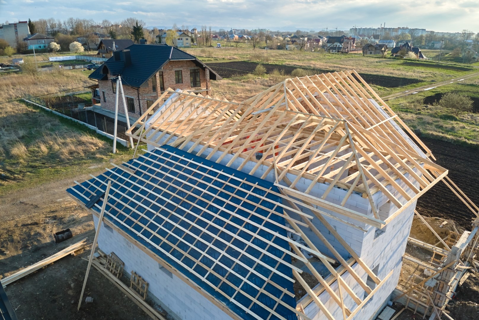 Wznoszenie więźby dachowej z impregnacją wstępną w Kędzierzynie-Koźlu, widok z góry na konstrukcję z drewna i bloczków.