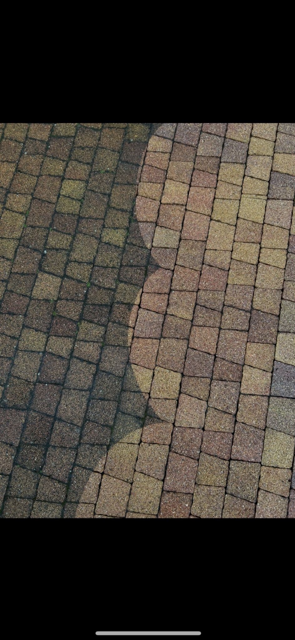 Kostka brukowa po częściowym czyszczeniu, widoczna różnica w kolorze i czystości. Ujęcie z góry, ukazujące kontrast między umytą a brudną powierzchnią.