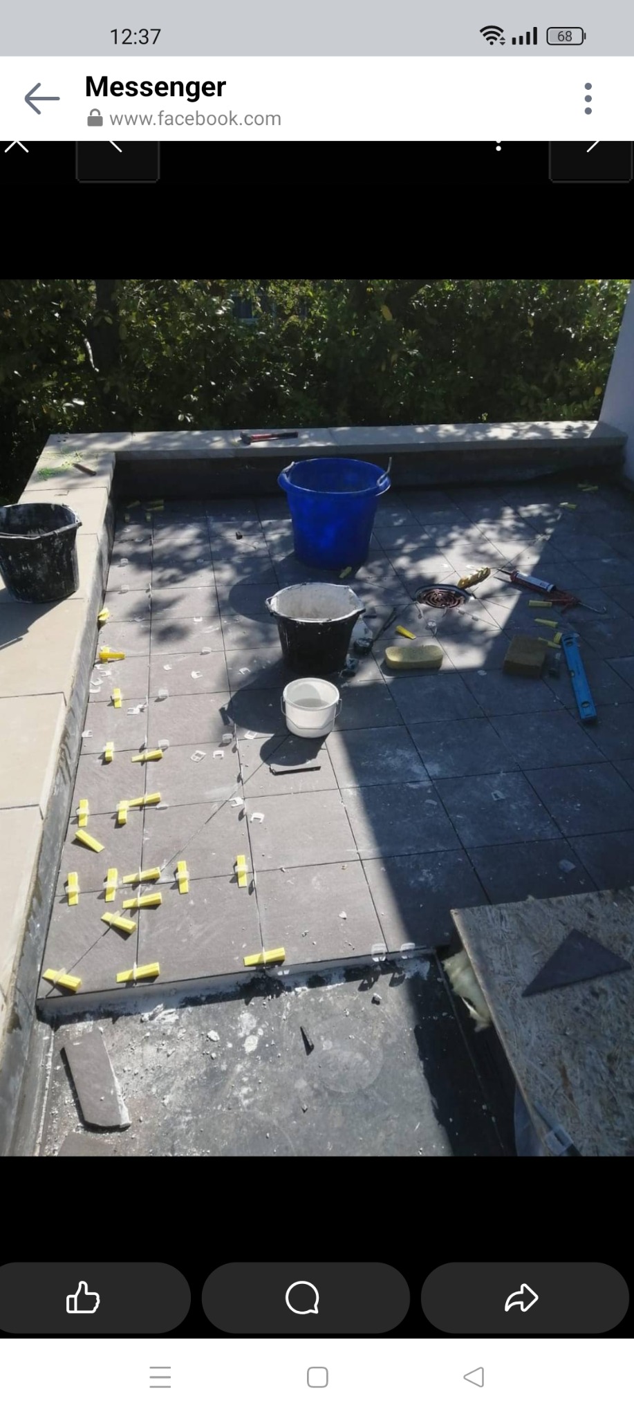 Montaż grafitowych płytek na tarasie, z widocznymi krzyżykami dystansowymi, wiadrami i narzędziami glazurniczymi.