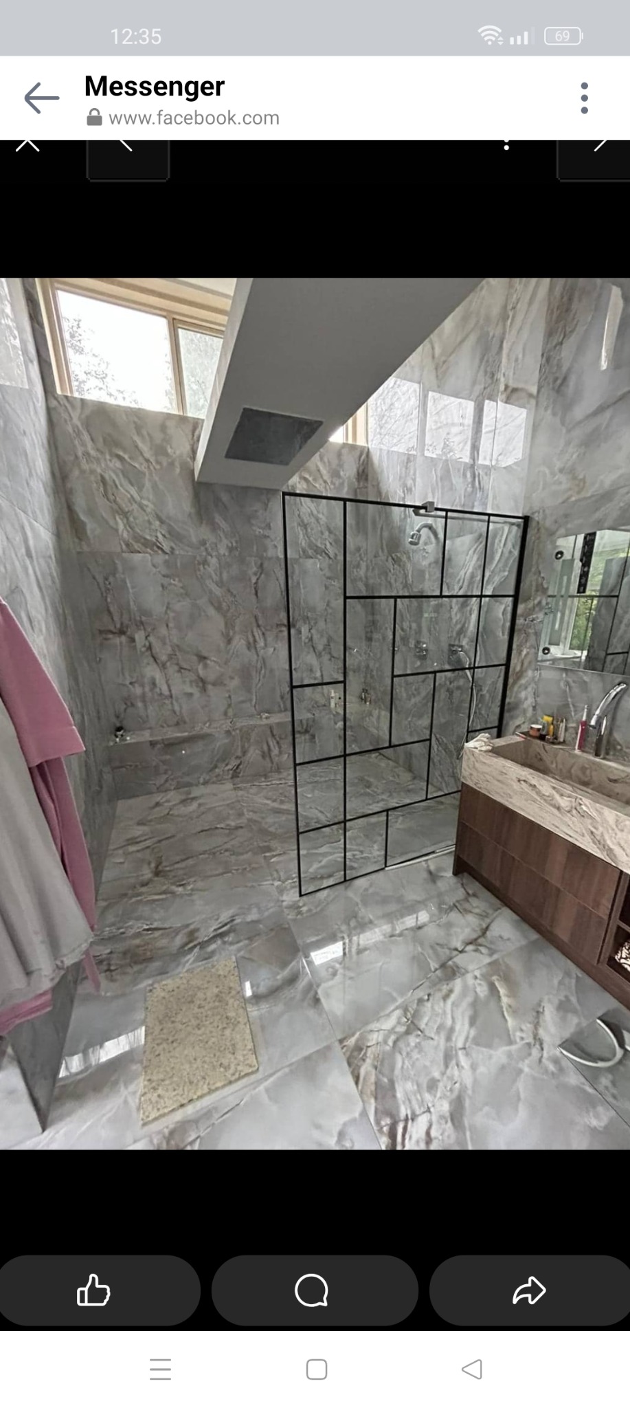 Nowoczesna łazienka wykończona płytkami imitującymi marmur, kabina prysznicowa z czarnymi profilami i geometrycznym podziałem szklanych tafli, drewniana szafka pod umywalką z marmurowym blatem.