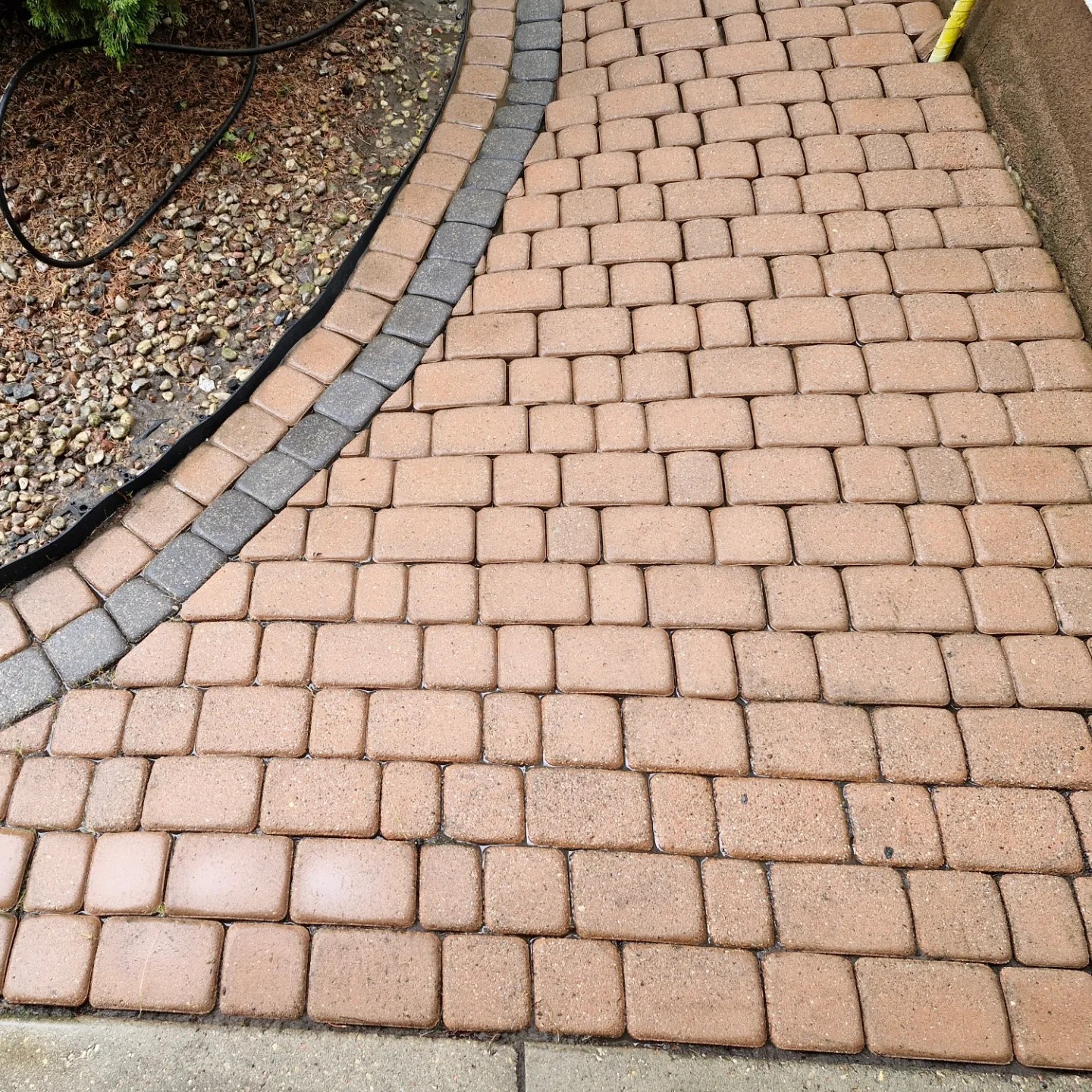 Czysta kostka brukowa po umyciu w Warszawie, z widocznymi detalami faktury i bordiurą z szarej kostki.