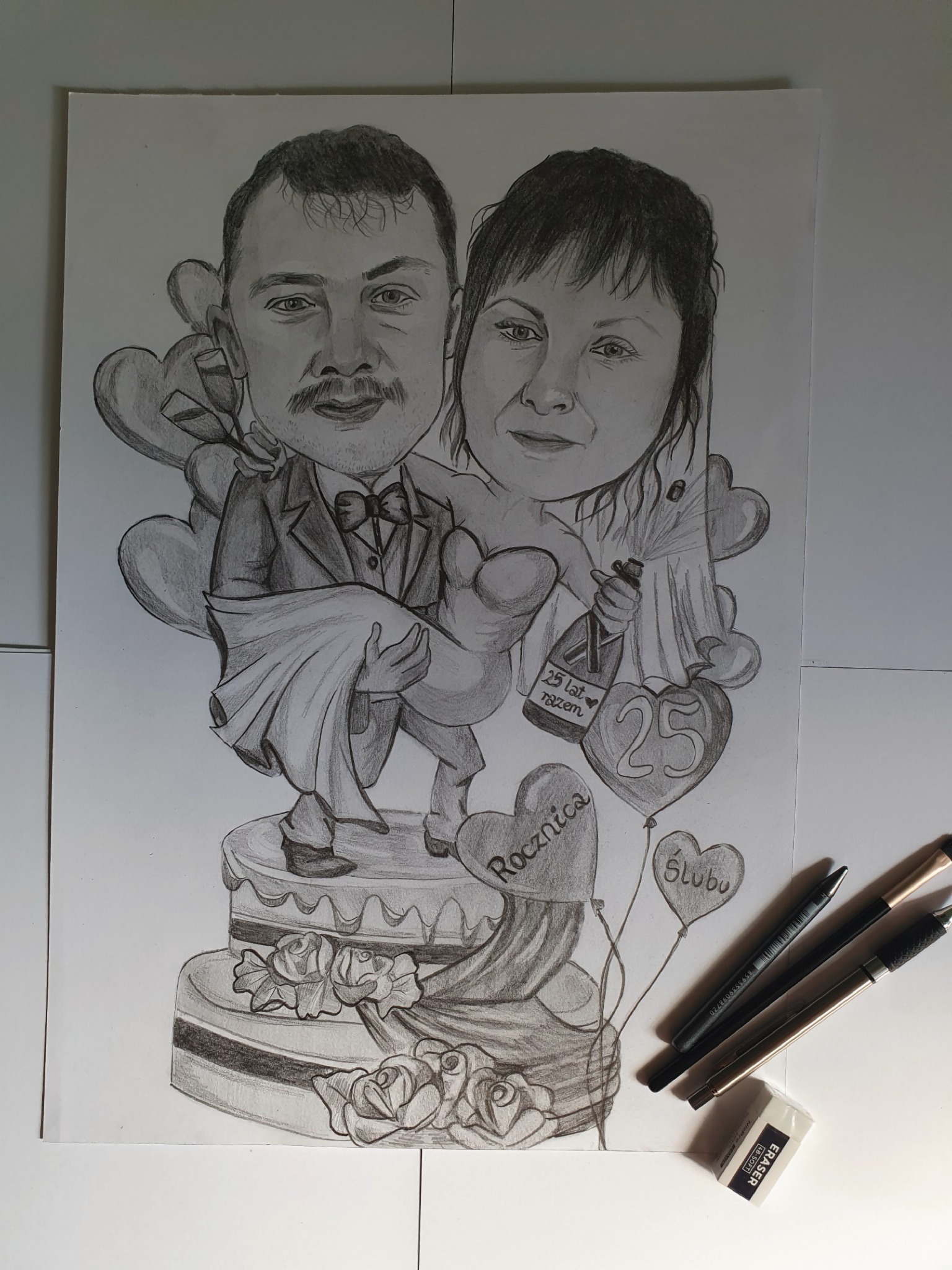 Ręcznie rysowana karykatura dwuosobowa na formacie A3, przedstawiająca parę stojącą na torcie rocznicowym, z balonami w kształcie serc i butelką szampana z napisem '25 lat razem'. Na stole leżą...