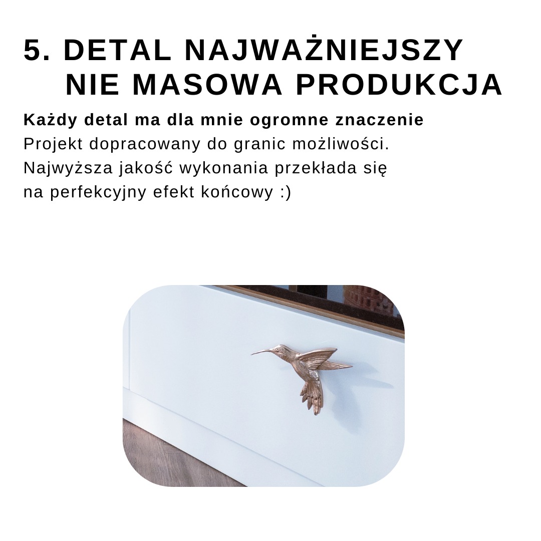 Biały front meblowy z dekoracyjnym uchwytem w kształcie kolibra w kolorze miedzi. Widoczne fragmenty blatu i podłogi.