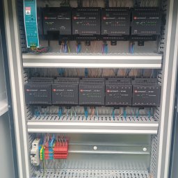 Instel - Wnętrze otwartej szafy sterowniczej z zamontowanymi modułami UNITRONICS, zasilaczem MW EDR-75-24 i kolorowym okablowaniem na szynach DIN.