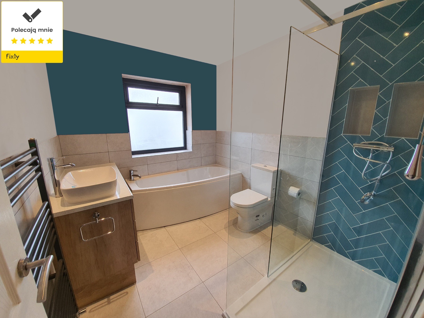 Wykończona łazienka z wanną, toaletą, umywalką na szafce z drewnianym frontem oraz kabiną prysznicową z turkusowymi płytkami ułożonymi w jodełkę.