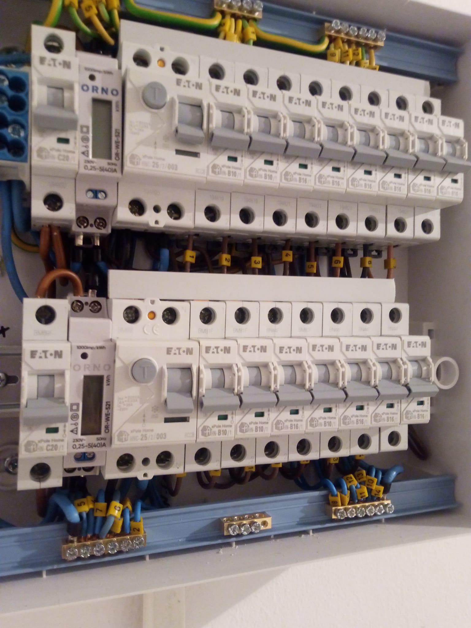 Rozdzielnica elektryczna z zamontowanymi bezpiecznikami EATON i licznikiem ORNO, okablowanie z oznacznikami, widok z bliska.