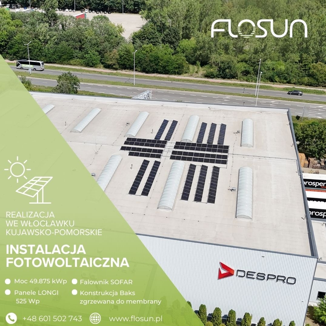 Instalacja paneli słonecznych na dachu hali przemysłowej z świetlikami, widok z góry, zieleń w tle. Realizacja we Włocławku, Kujawsko-Pomorskie.