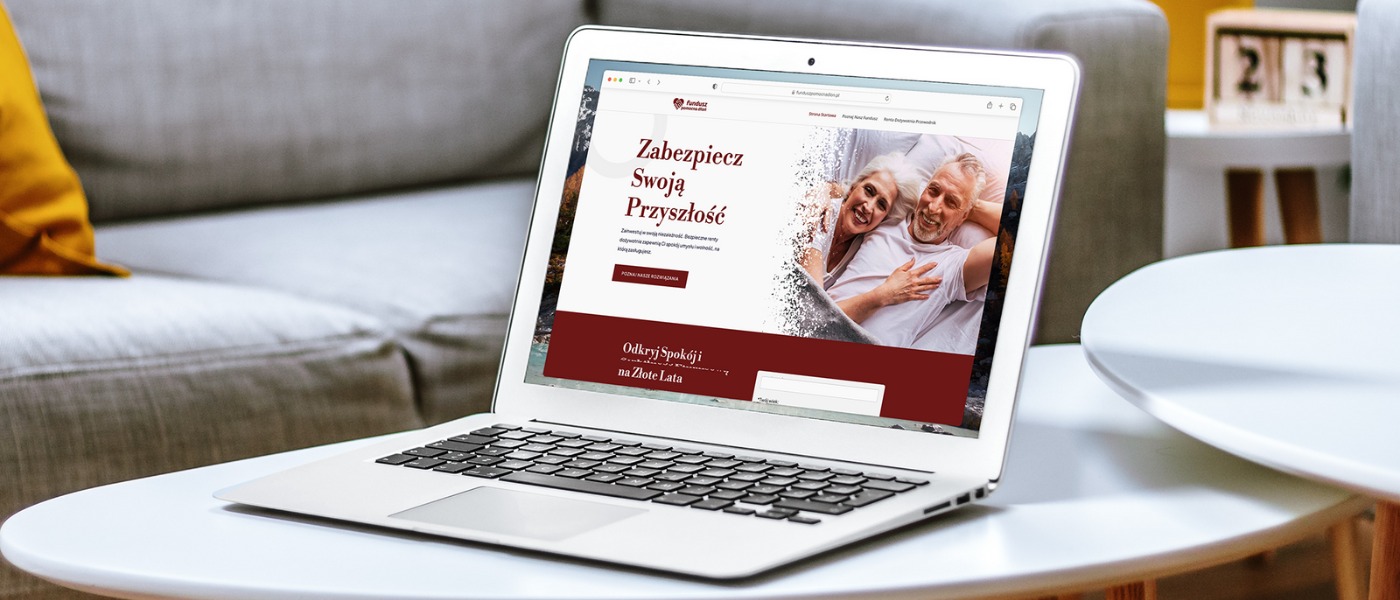 Laptop na stole prezentuje stronę internetową z hasłem 'Zabezpiecz Swoją Przyszłość' i zdjęciem uśmiechniętej pary seniorów. Stonowana kolorystyka, nowoczesny design.