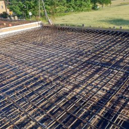 FRB ORAWIEC Wojciech Orawiec - Siatka zbrojeniowa ułożona na czarnej folii, przygotowana do wylania fundamentów pod budynek, widok z góry.