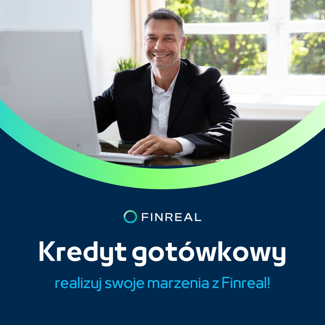 Uśmiechnięty mężczyzna w garniturze siedzi przy biurku z komputerem, w tle okno, nad nim logo Finreal i napis 'Kredyt gotówkowy - realizuj swoje marzenia z Finreal!'.