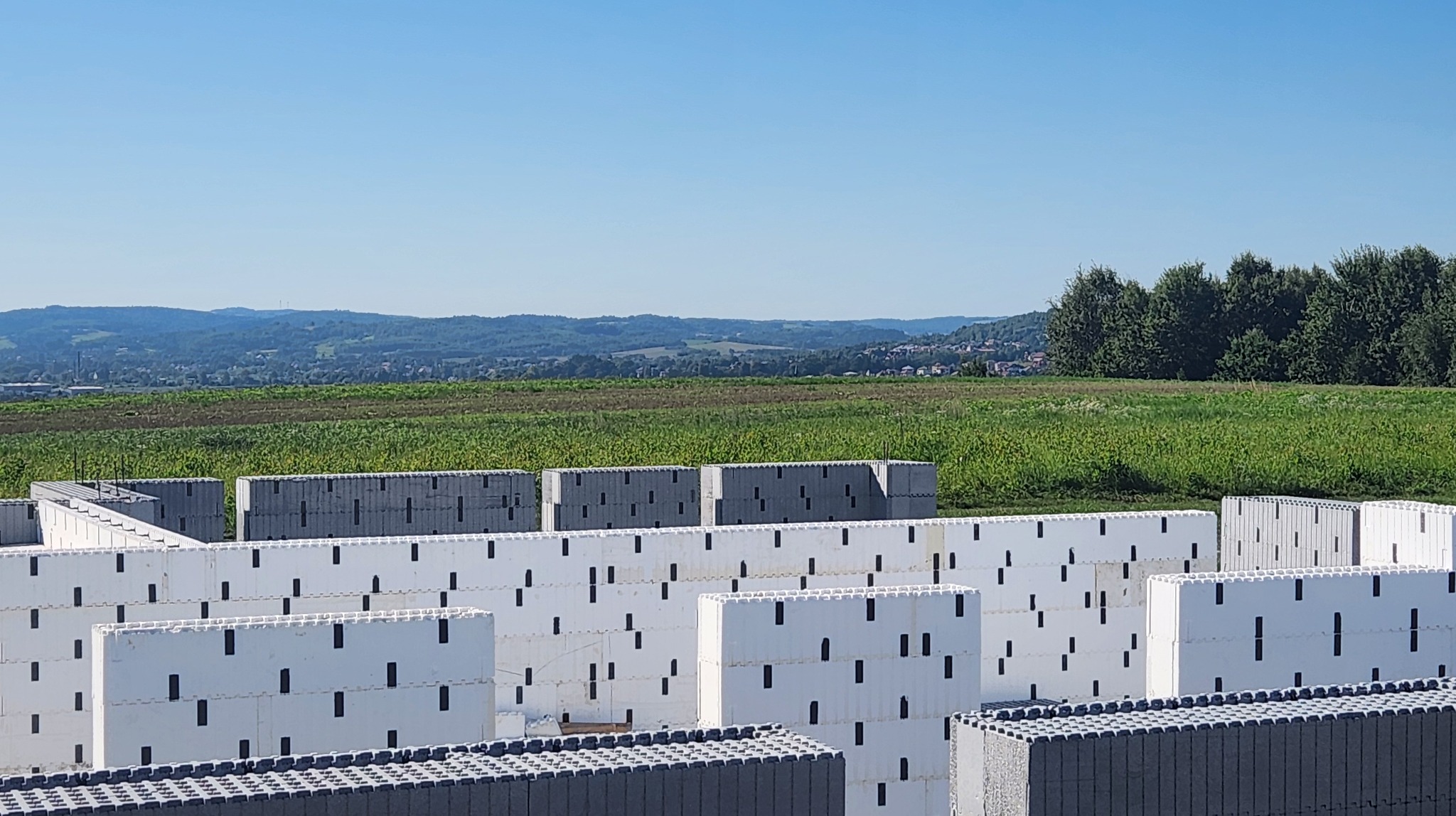 Ściany domu w trakcie budowy w systemie szalunku traconego z widokiem na krajobraz