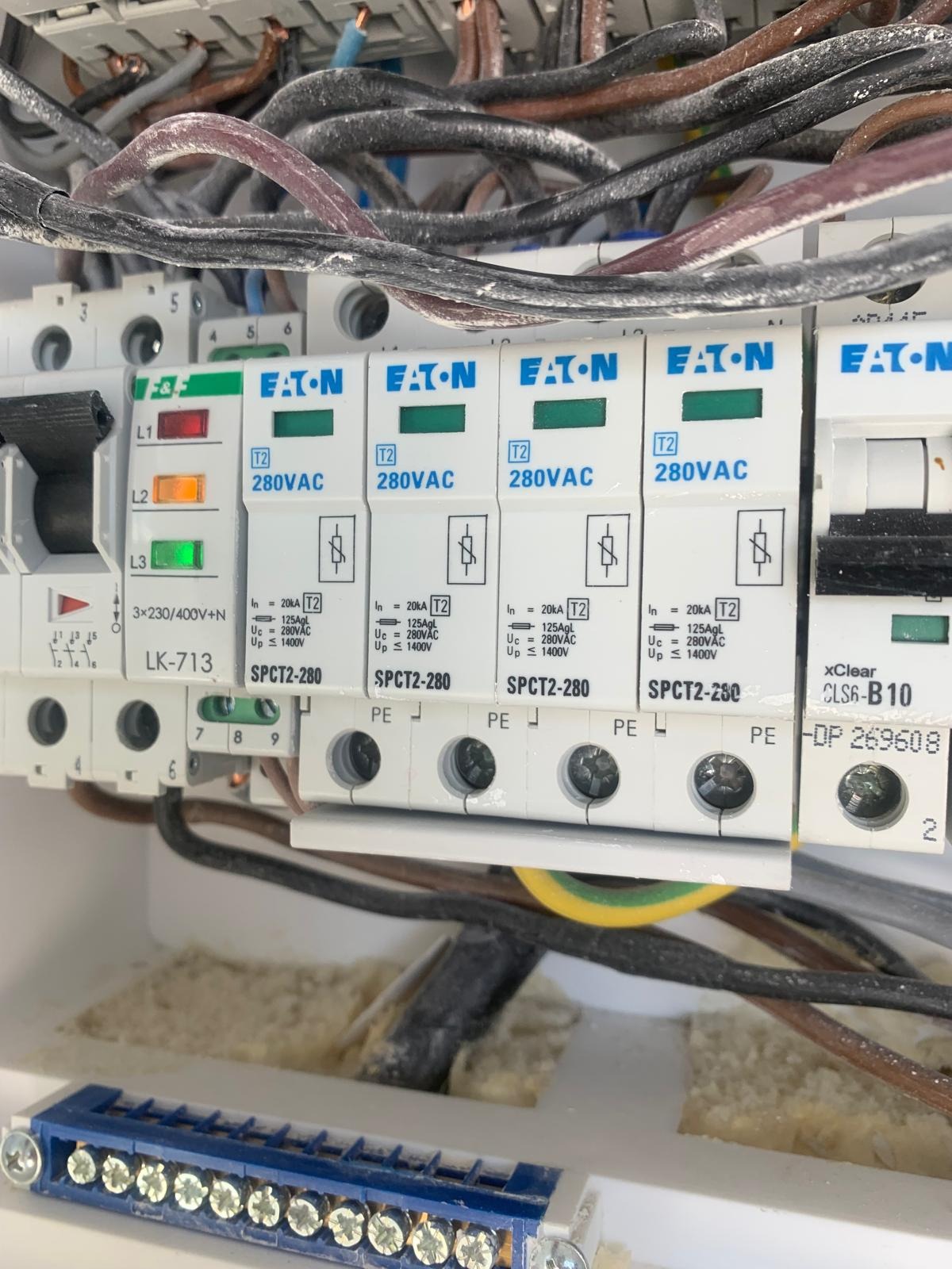 Rozdzielnica elektryczna z zabezpieczeniami przeciwprzepięciowymi marki Eaton SPCT2-280, widoczne przewody i listwa zaciskowa z niebieską obudową.