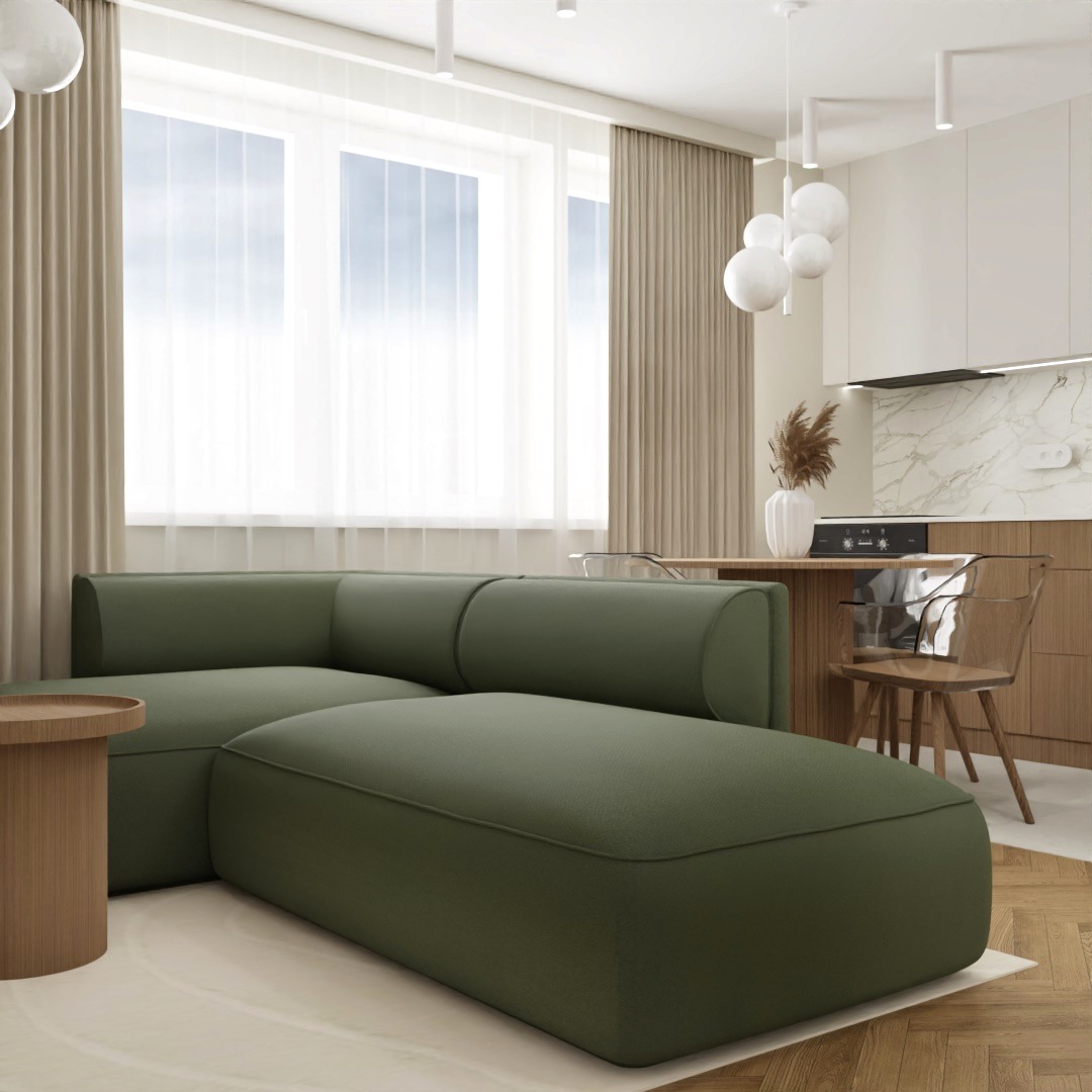 Nowoczesny salon z narożną sofą w odcieniach zieleni, drewnianym stolikiem kawowym, jasną kuchnią z marmurowym blatem w tle i drewnianą podłogą.