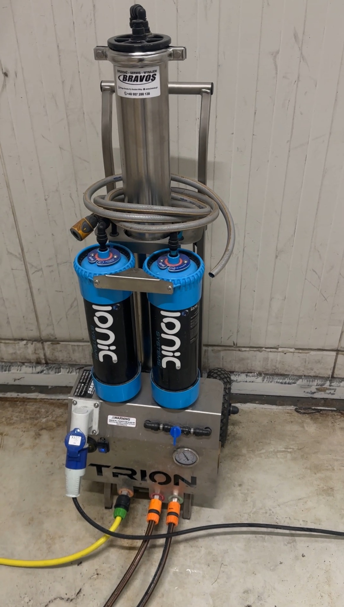 Profesjonalny sprzęt do demineralizacji wody Ionic Systems Trion, z filtrami i wężami, gotowy do użycia przy myciu okien. Widoczne detale i złącza.