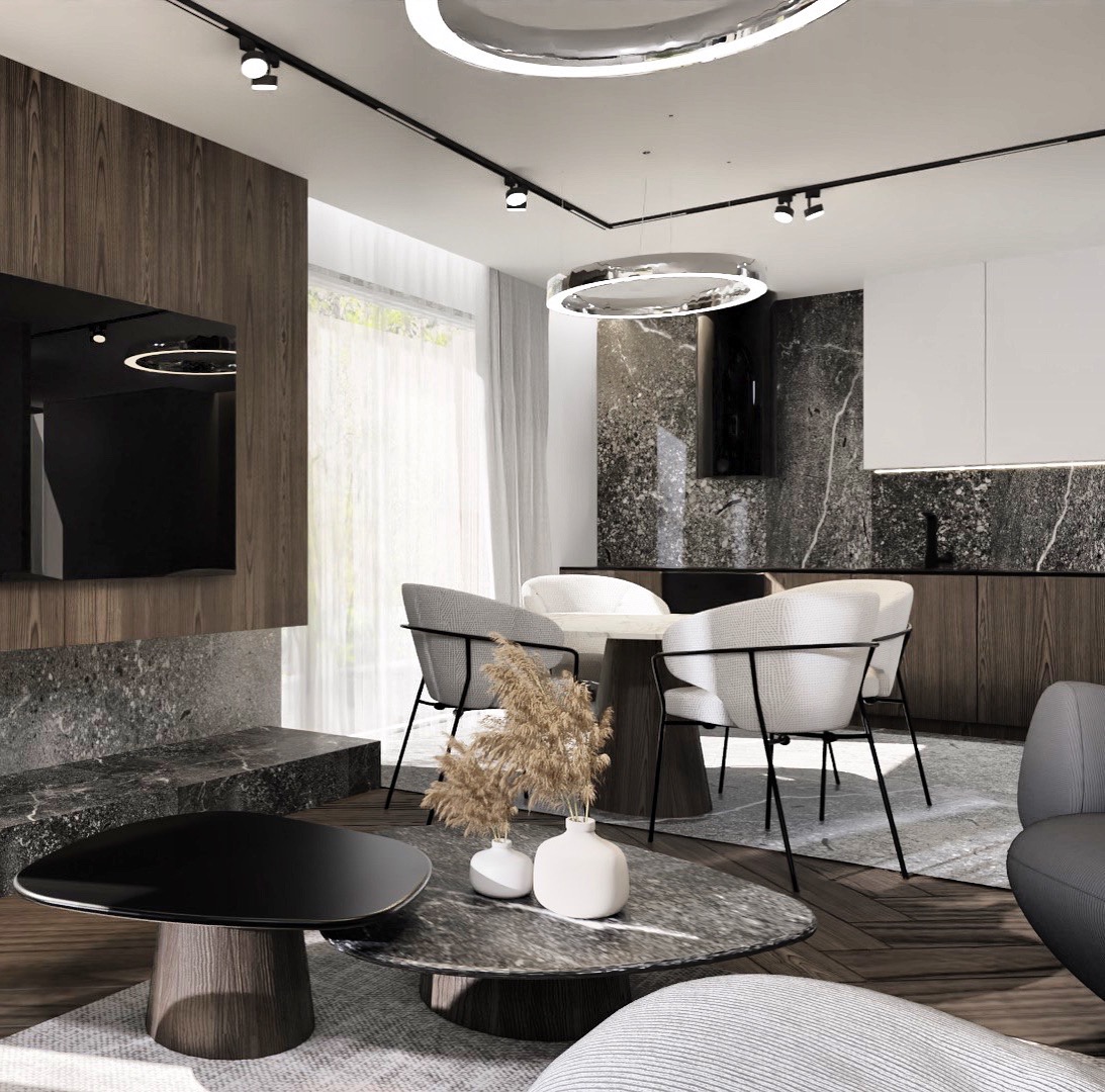 Nowoczesne wnętrze salonu z aneksem kuchennym, marmurowe wykończenia, okrągły stół z białymi krzesłami, designerskie lampy sufitowe, dekoracyjny bukiet w ceramicznych wazonach na stoliku kawowym.