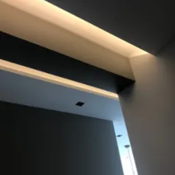 Nowoczesne wykończenie sufitu z oświetleniem LED w Dąbrowie Górniczej, widok pod kątem, ciemnoszare ściany i białe elementy dekoracyjne.