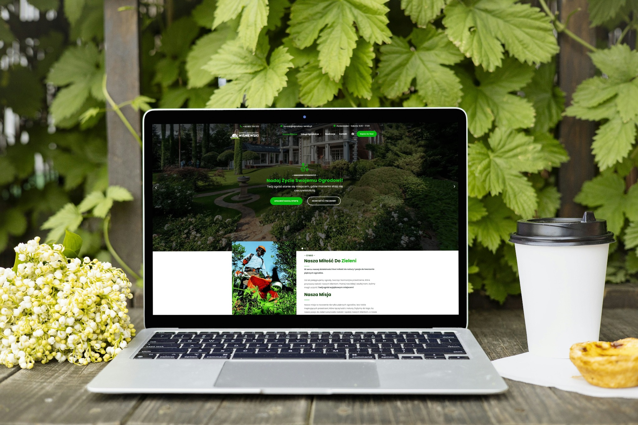 Laptop na drewnianym stole prezentuje stronę internetową firmy ogrodniczej, z bliska kwiaty i kawa. Tło to zielone liście. Unikalne ujęcie z naturalnym światłem.