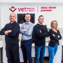 WINLUX Jakub Turowski - Zespół Vetrex, czterech uśmiechniętych pracowników z założonymi rękami, na tle logo firmy z napisem 'okna i drzwi premium'.