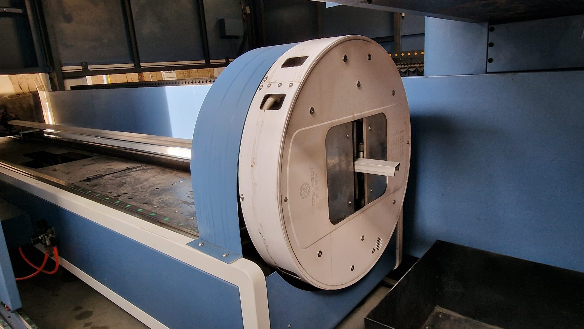 Proces obróbki CNC aluminium: Profil aluminiowy umieszczony w maszynie CNC z okrągłą głowicą, widoczny w warsztacie.